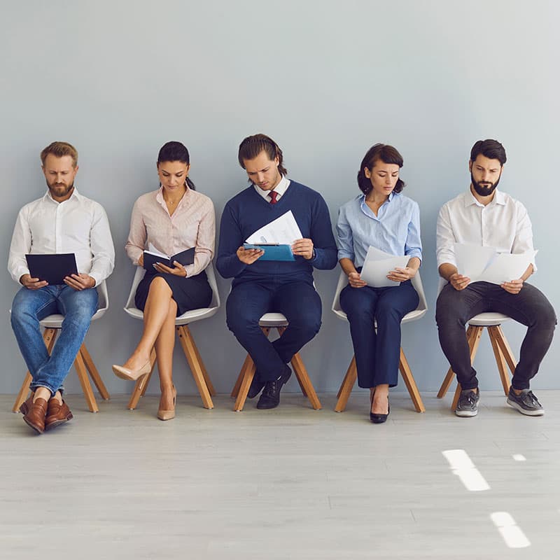 Candidate sitting in a waiting room reviewing application paperwork