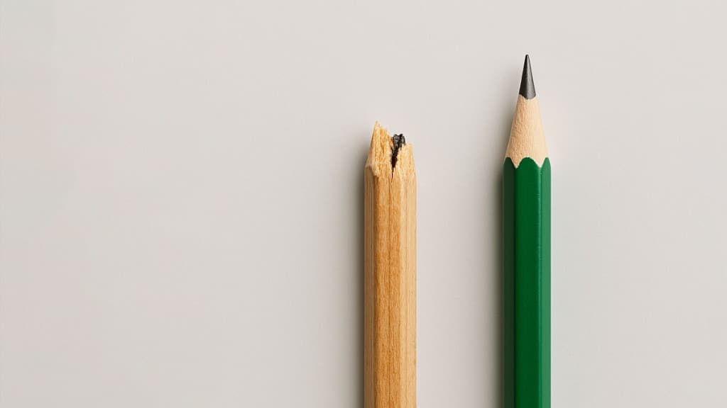 Broken pencil beside sharpened pencil contrasting disrepair with readiness